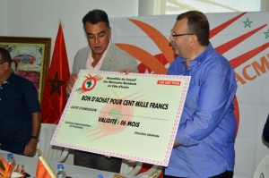 Le pr&eacute;sident de ACMRCI Ouazzani Chahdi (chemise bleu &agrave; droite) et l'ambassadeur du Maroc en C&ocirc;te d'Ivoire Abdelmalek Kettani (Veste &agrave; gauche) tenant un bon symbolique de 100.000 FCFA remis &agrave; une famille musulmane